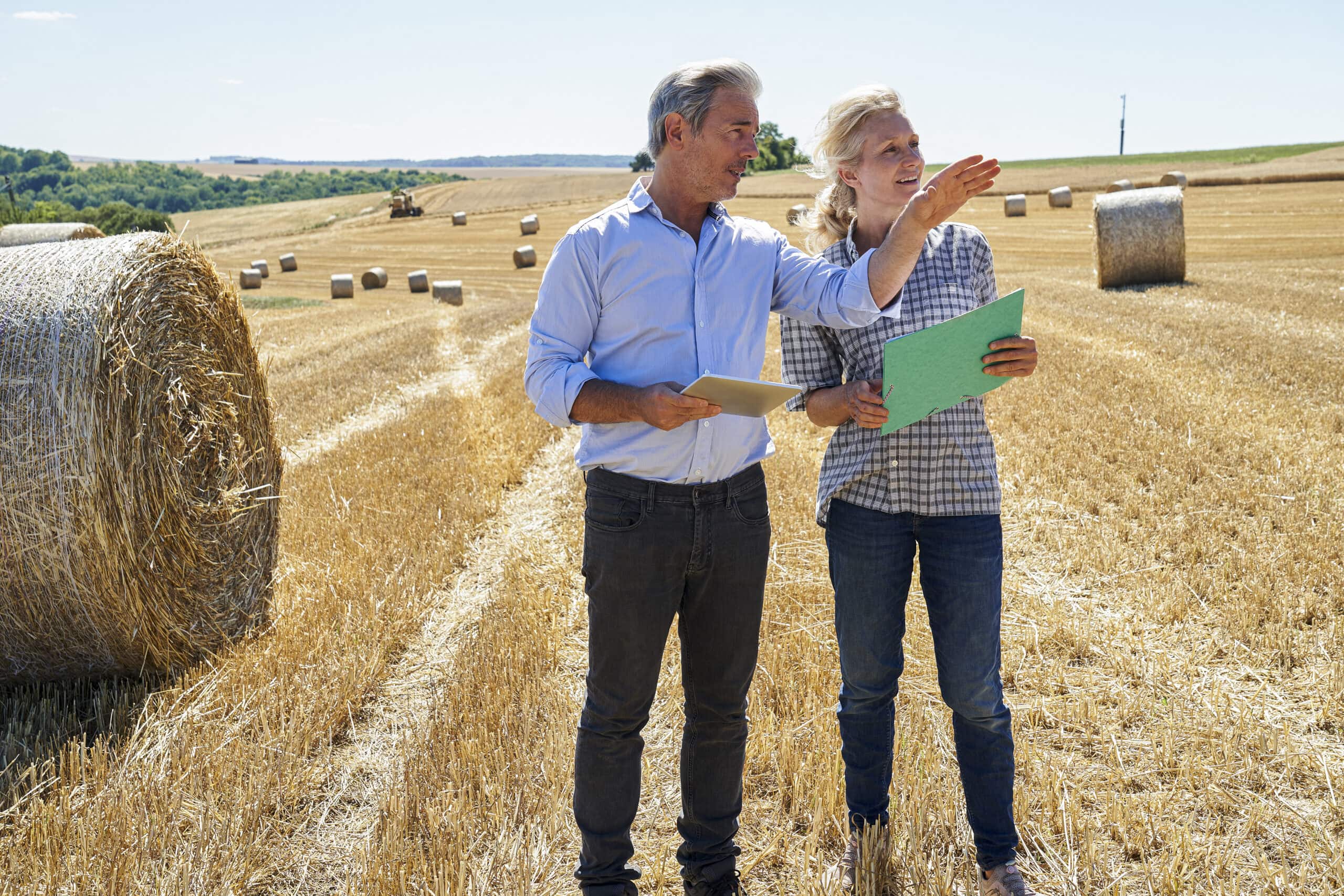 Local land expert showing a client available property in a field, helping them explore land for sale near you.