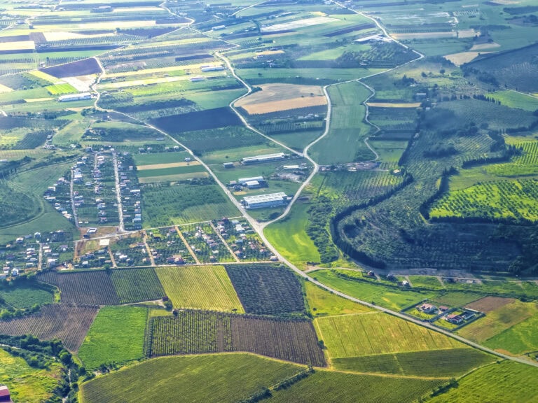 Aerial view of diverse land types including agricultural, residential, and recreational properties, representing land for sale near me.