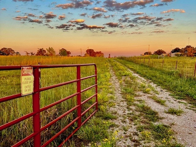 Fenced field with gate on land for sale in Oklahoma under open sky